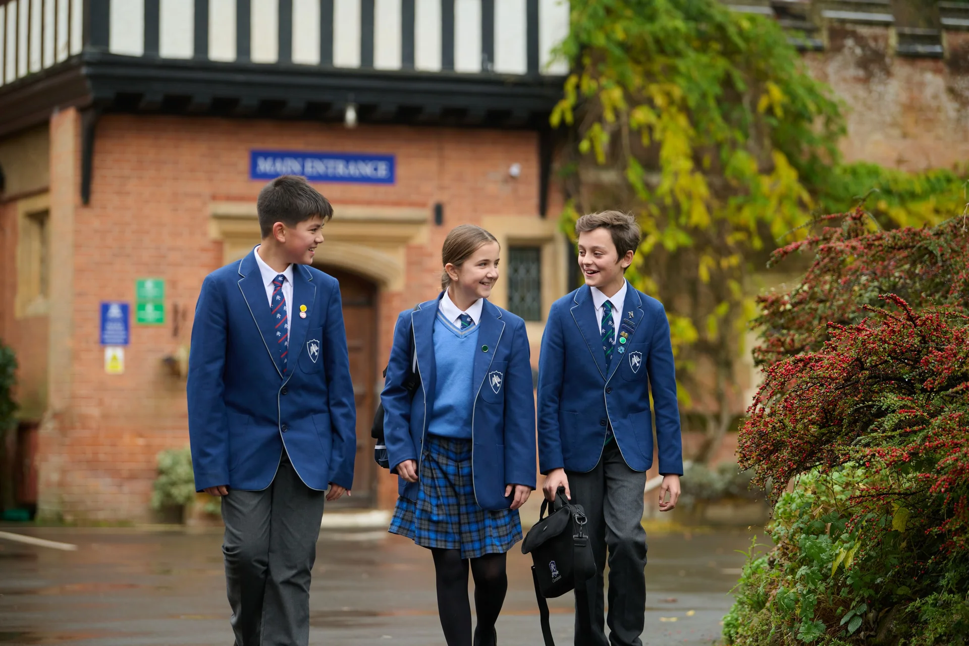 three  students walking outside the school