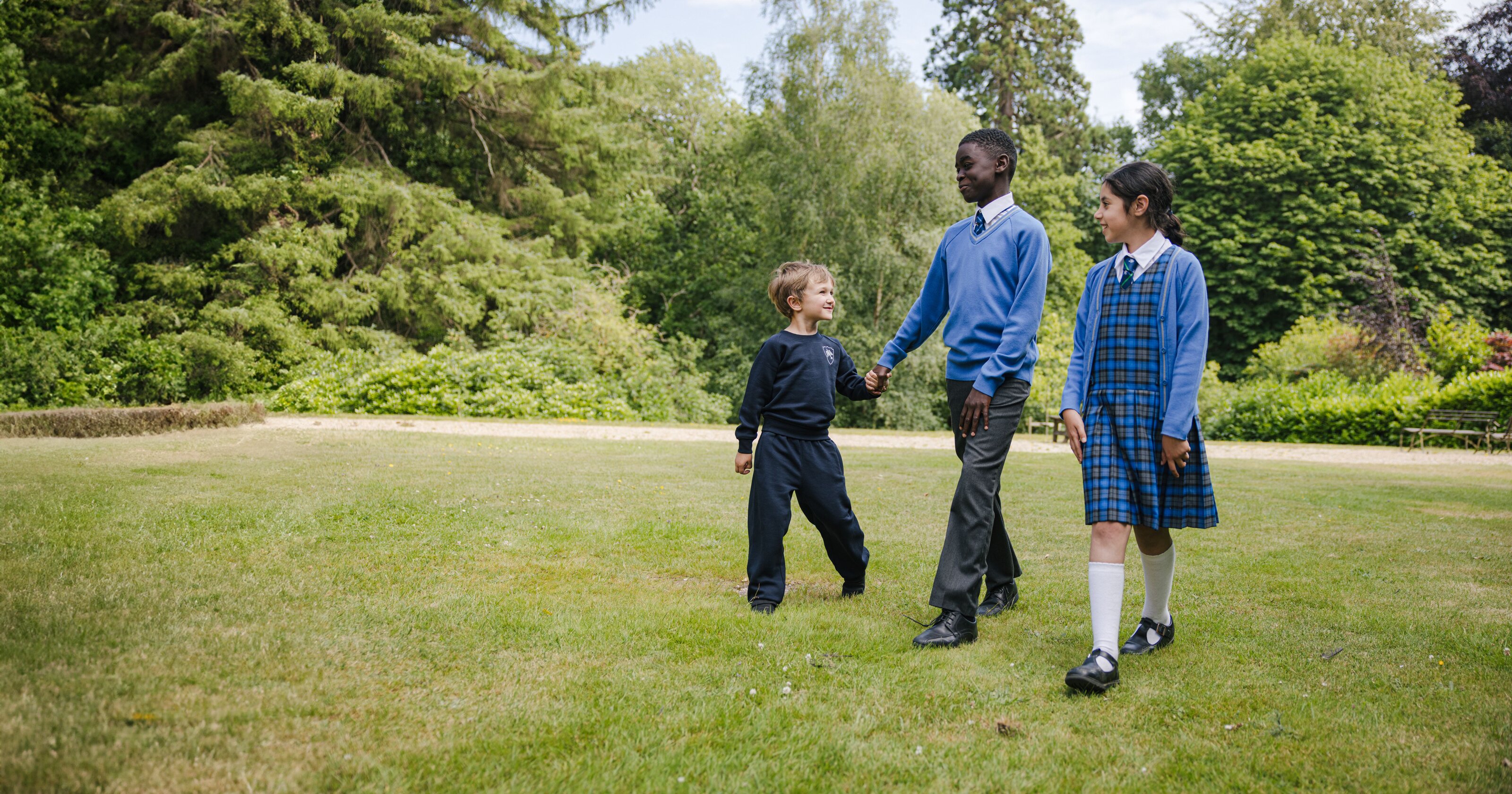 three students walking in the schoolyard