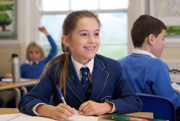 a student writing and smiling