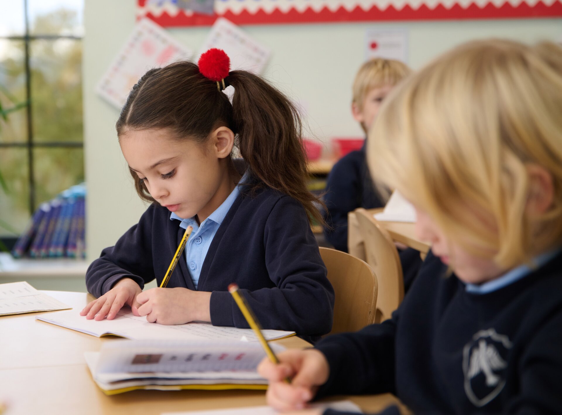 two students writing in the classroom