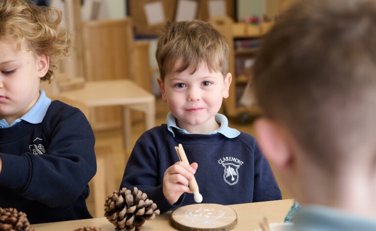 students doing wood and pinecone crafts