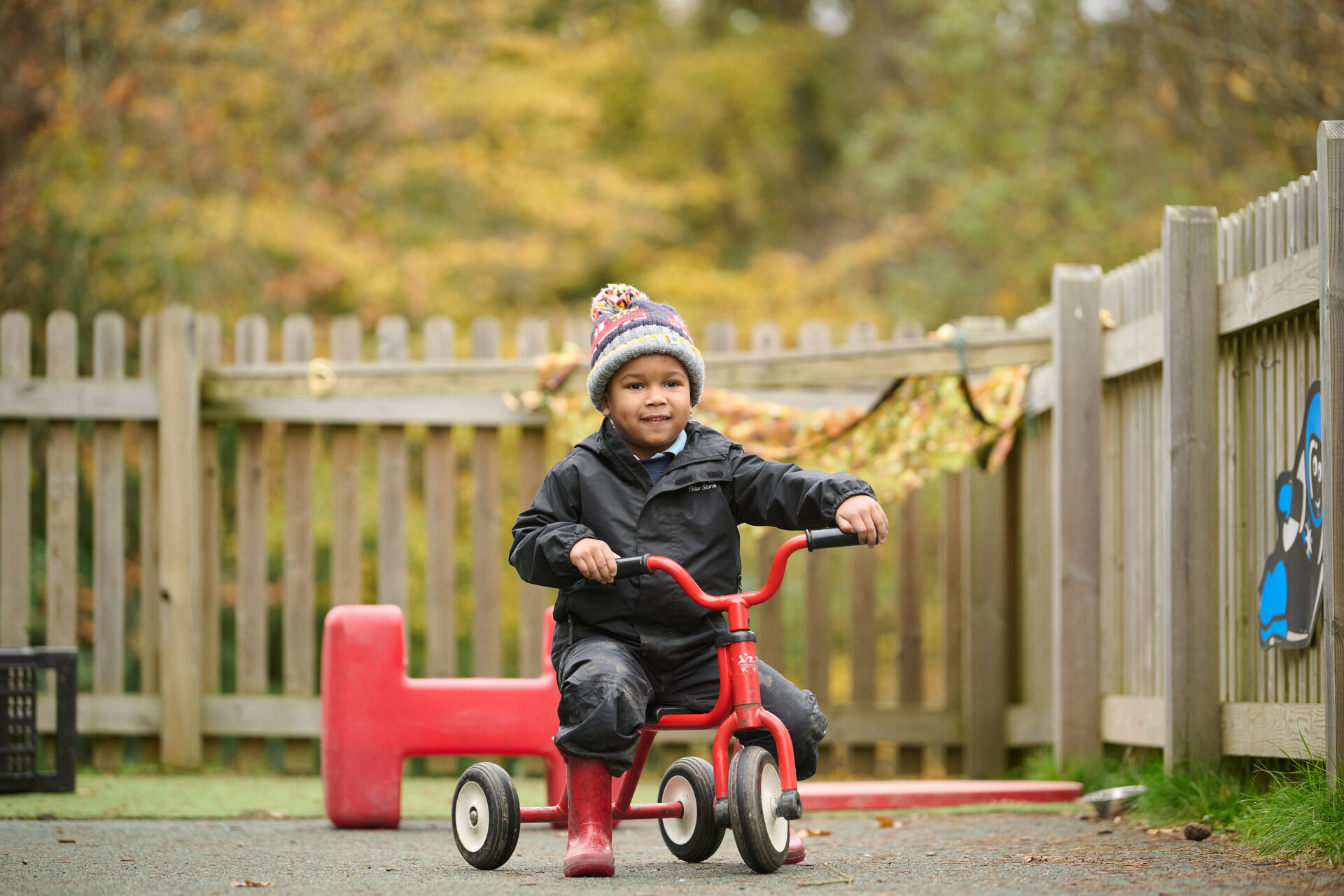 student on a kids' tricycle