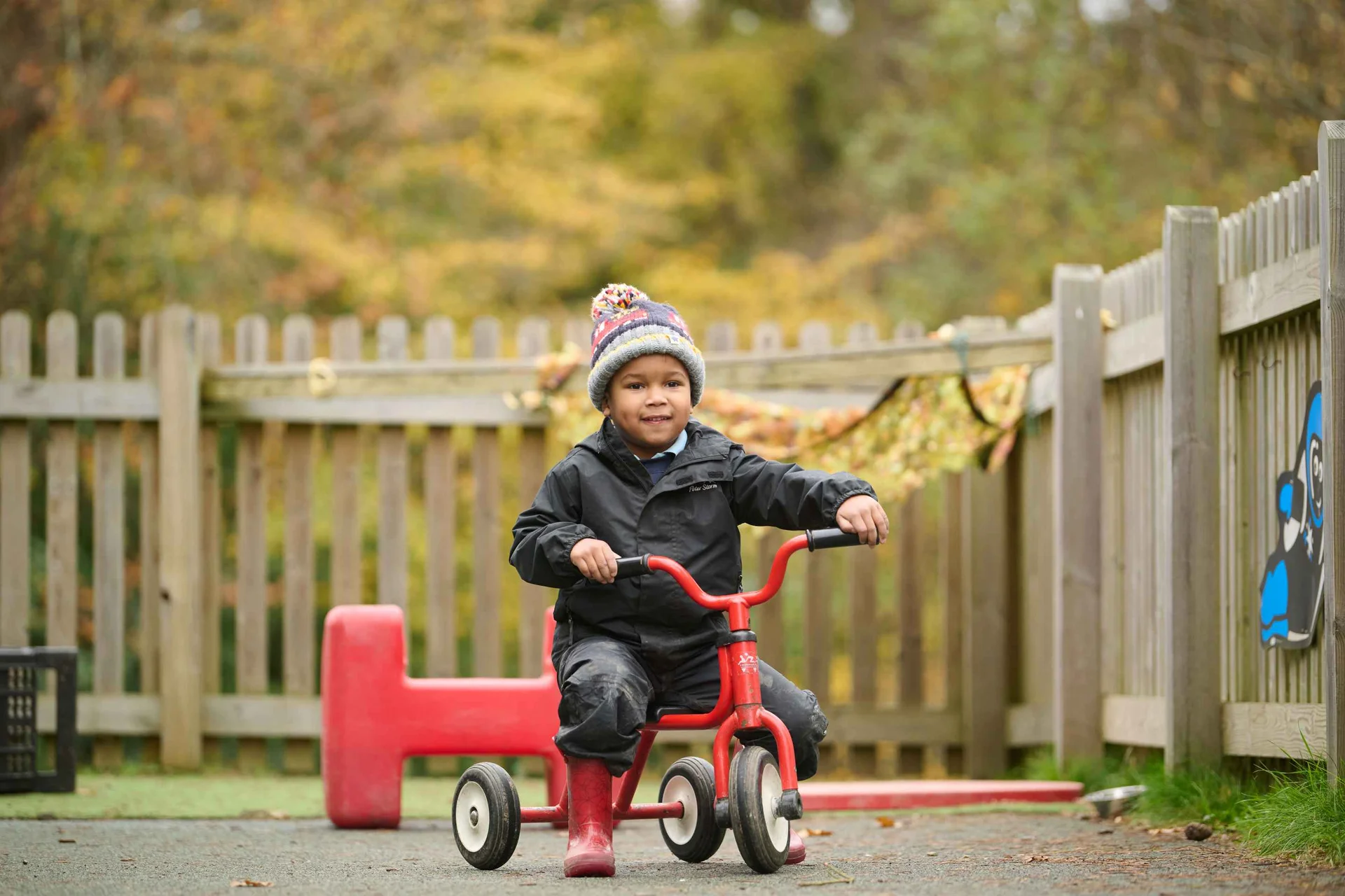 student on a kids' tricycle
