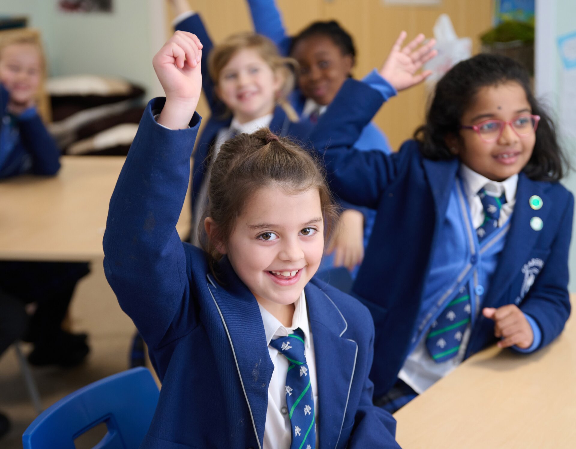 student in the classroom raising hand