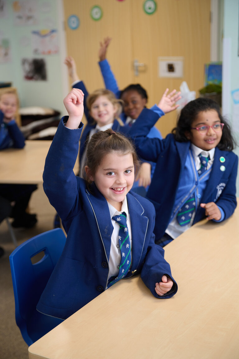 student in the classroom raising hand